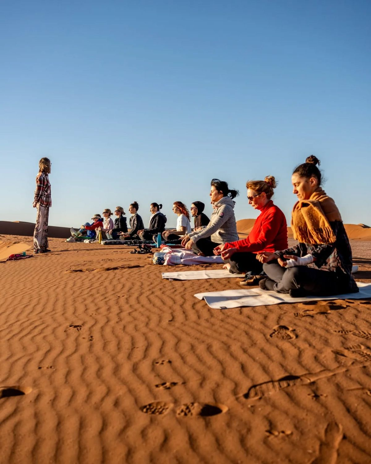 Méditation de groupe sur les dunes